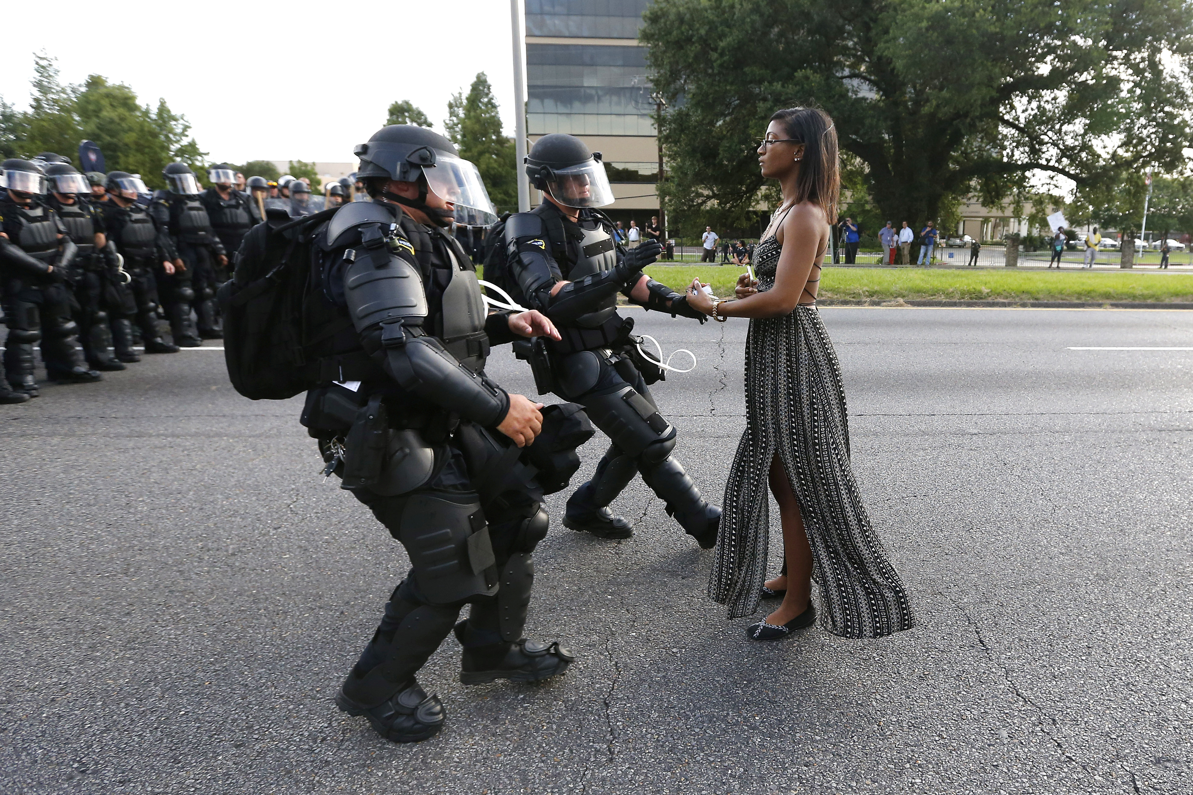 Ieshia Evans, a nurse from Pennsylvania, stands alone on a street as police in riot gear move to arrest her.